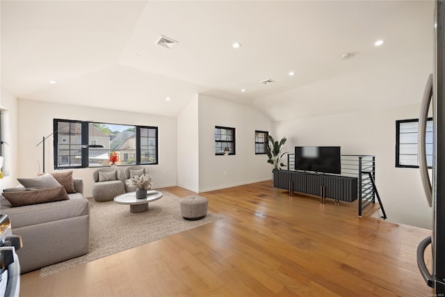 living room featuring vaulted ceiling, recessed lighting, visible vents, and light wood-style floors