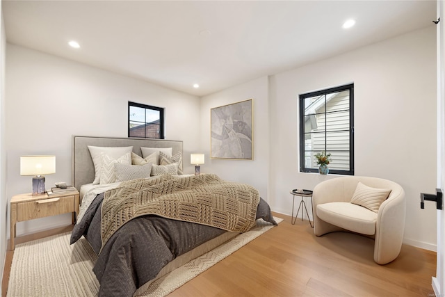 bedroom with baseboards, wood finished floors, and recessed lighting