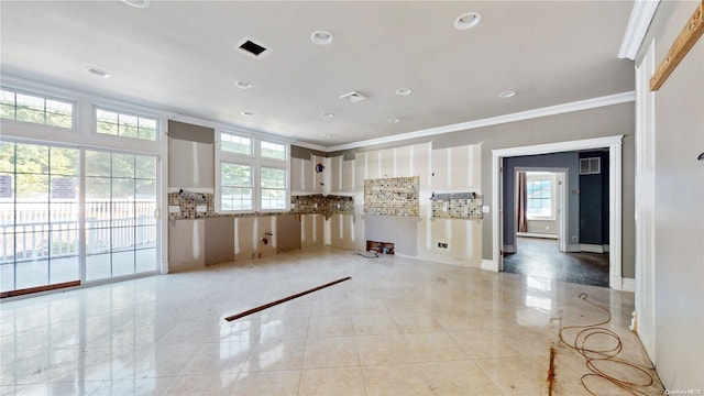 unfurnished living room with ornamental molding