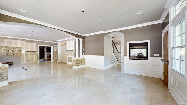 entryway featuring light tile patterned flooring, ornate columns, and crown molding