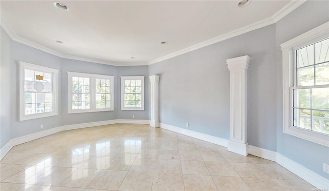 spare room featuring crown molding and decorative columns