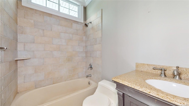 full bathroom with vanity, tiled shower / bath combo, and toilet