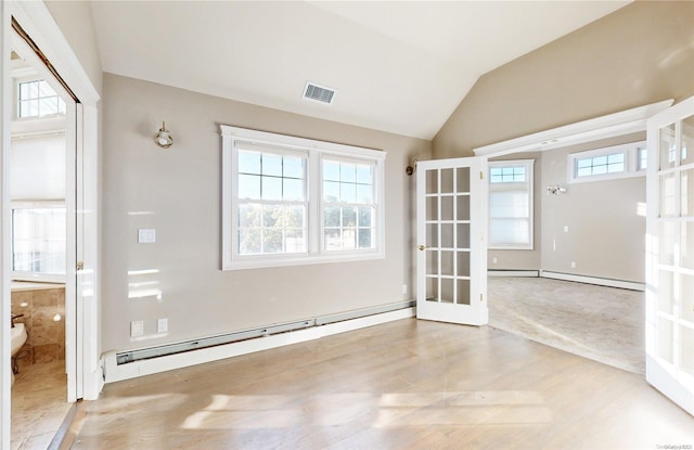 spare room with french doors, baseboard heating, and vaulted ceiling