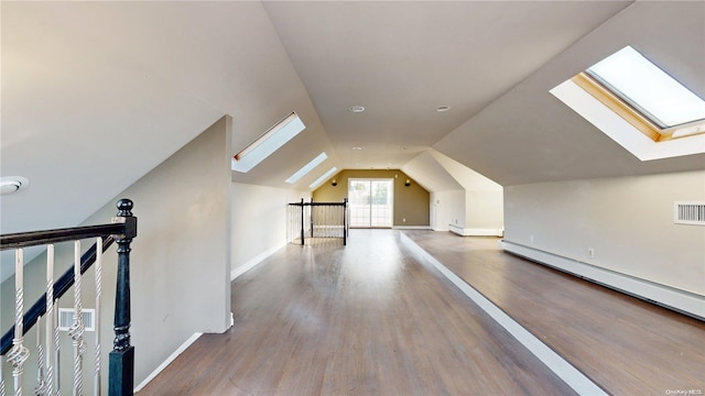 bonus room with vaulted ceiling with skylight, wood-type flooring, and a baseboard radiator