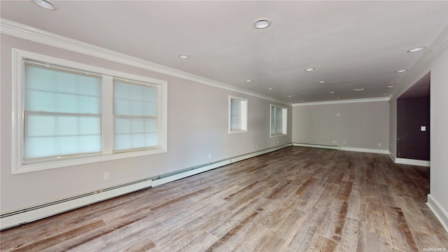 spare room featuring light wood-type flooring, baseboard heating, and ornamental molding