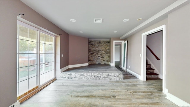 unfurnished living room with a baseboard radiator and light wood-type flooring