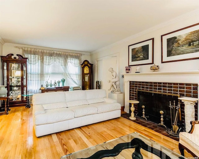 living room with a tile fireplace, hardwood / wood-style floors, and ornamental molding