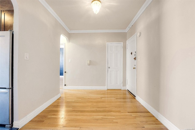 corridor with light hardwood / wood-style flooring and crown molding