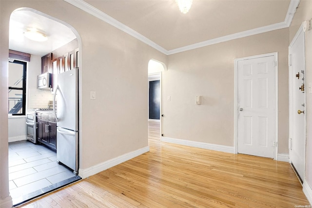 empty room with light hardwood / wood-style flooring and ornamental molding