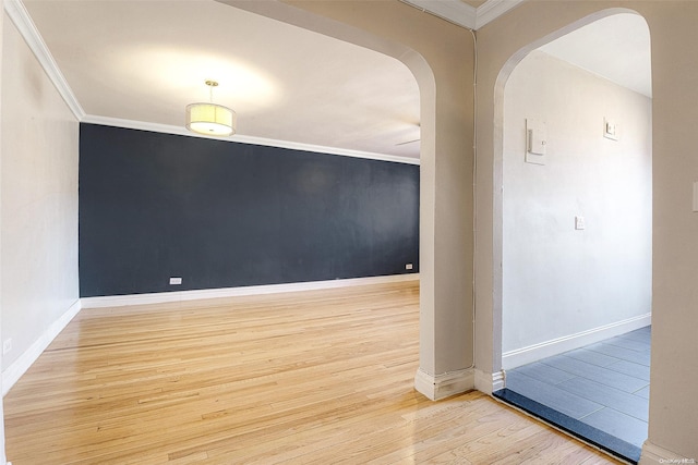 spare room featuring light wood-type flooring and ornamental molding