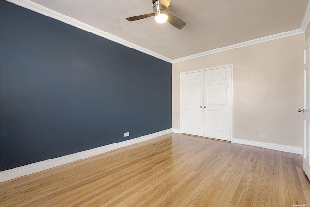 unfurnished bedroom with light wood-type flooring, a closet, ceiling fan, and crown molding