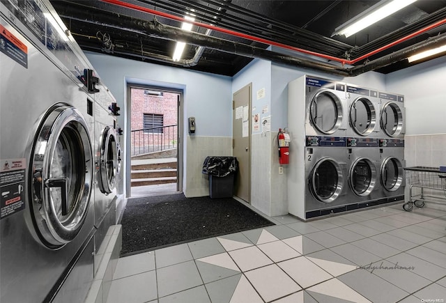 clothes washing area featuring washer and dryer, tile patterned flooring, tile walls, and stacked washer / drying machine