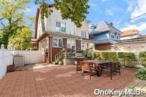 rear view of property with outdoor dining area, a patio area, and a fenced backyard