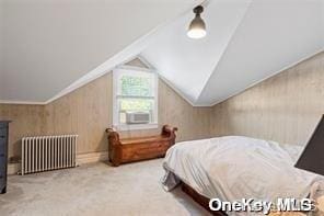 bedroom with vaulted ceiling, radiator heating unit, and carpet flooring