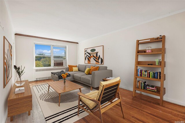 living room featuring radiator heating unit, ornamental molding, and hardwood / wood-style flooring