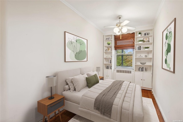 bedroom with radiator, ceiling fan, crown molding, and dark wood-type flooring