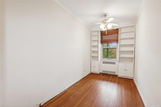 unfurnished room with hardwood / wood-style flooring, ceiling fan, crown molding, and radiator