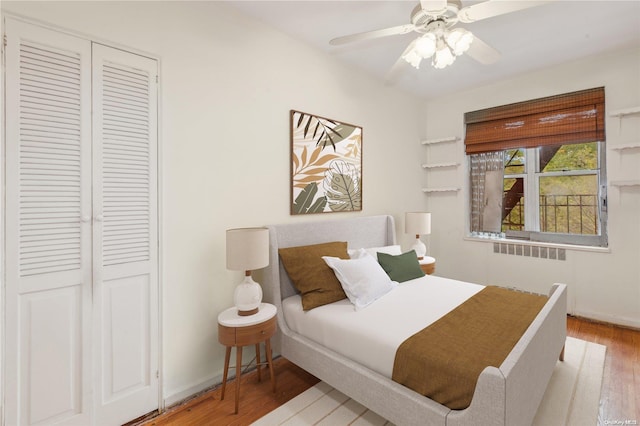 bedroom featuring wood-type flooring, radiator heating unit, a closet, and ceiling fan