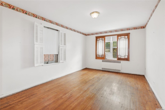 unfurnished room with radiator and light hardwood / wood-style flooring