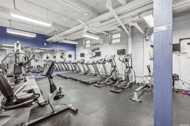 gym with an AC wall unit and ceiling fan