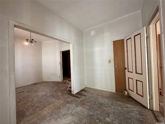 unfurnished room featuring a notable chandelier