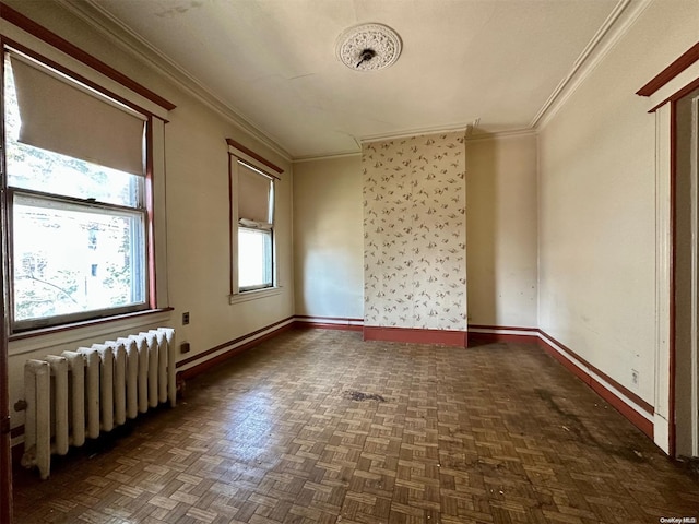 spare room with radiator heating unit, dark parquet floors, and ornamental molding