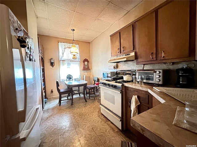 kitchen with pendant lighting, white appliances, backsplash, and light tile patterned floors