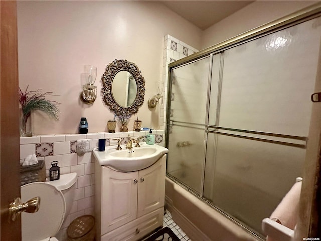 full bathroom featuring vanity, tile walls, enclosed tub / shower combo, tile patterned flooring, and toilet