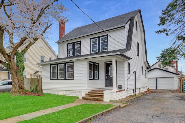 view of front of house featuring a garage, an outdoor structure, and a front yard