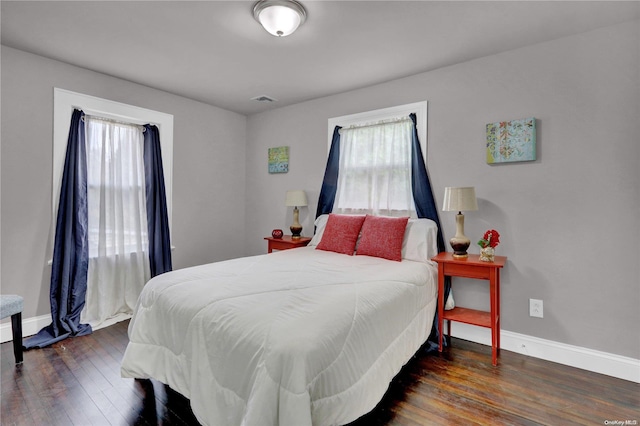 bedroom with dark hardwood / wood-style floors