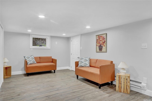 living area featuring a baseboard heating unit and light wood-type flooring