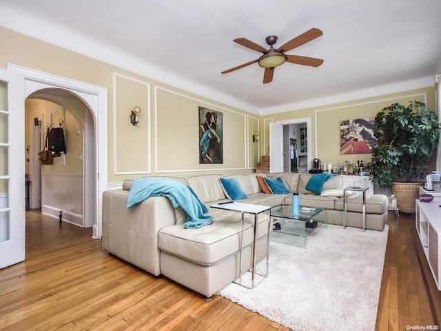 living room featuring built in shelves, ceiling fan, and hardwood / wood-style floors