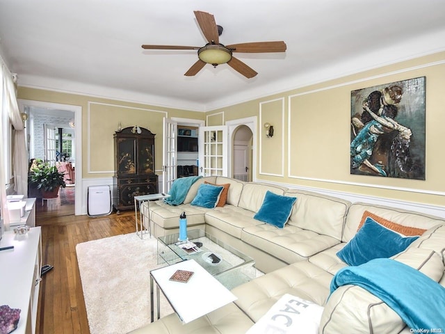 living room with ceiling fan, wood-type flooring, and ornamental molding