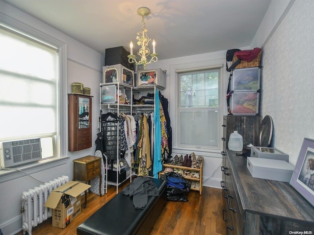 workout room featuring radiator heating unit, dark hardwood / wood-style flooring, and a notable chandelier