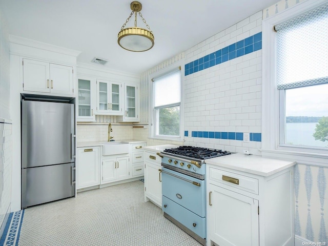 kitchen with white cabinets, appliances with stainless steel finishes, a healthy amount of sunlight, and sink