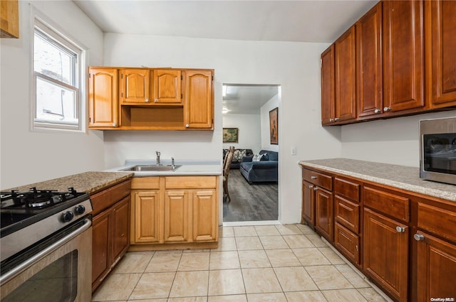 kitchen featuring light tile patterned flooring, sink, and stainless steel appliances