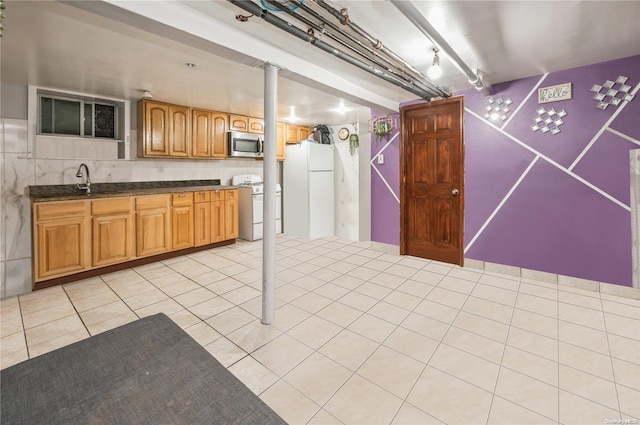 kitchen with light tile patterned flooring, white appliances, and sink