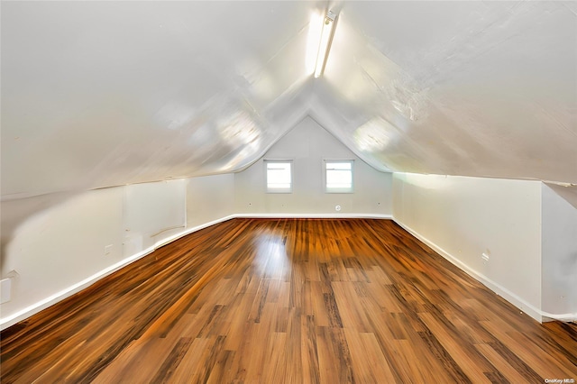 bonus room with hardwood / wood-style floors and vaulted ceiling