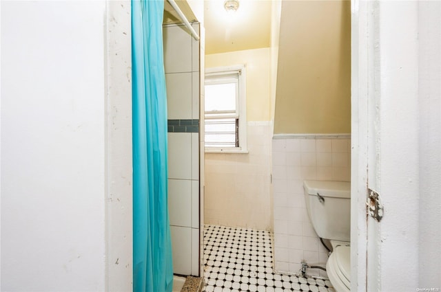 bathroom with walk in shower, tile walls, and toilet