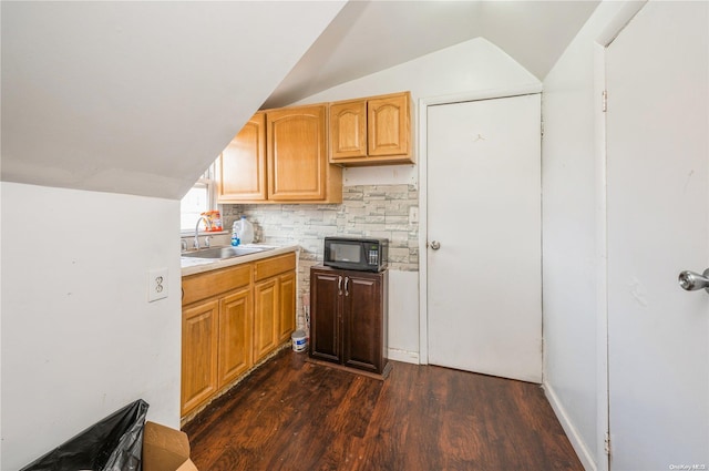 kitchen featuring decorative backsplash, sink, dark wood-type flooring, and vaulted ceiling