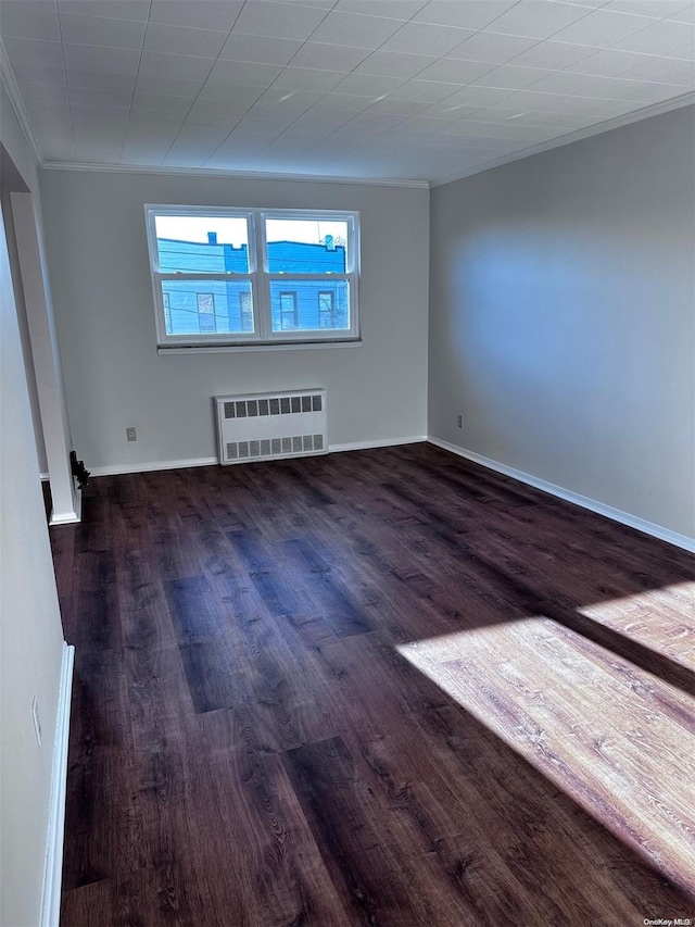 empty room featuring radiator, crown molding, and dark hardwood / wood-style floors