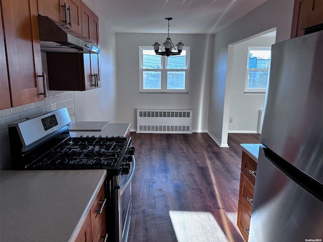 kitchen featuring appliances with stainless steel finishes, a wealth of natural light, radiator, and a notable chandelier