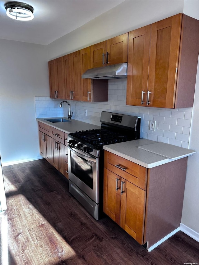 kitchen with backsplash, dark hardwood / wood-style floors, stainless steel range with gas cooktop, and sink