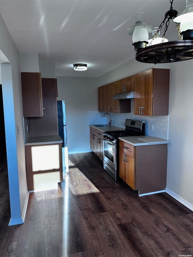 kitchen featuring backsplash, sink, fridge, gas stove, and dark hardwood / wood-style flooring