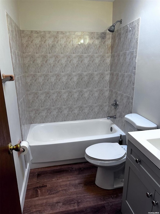 full bathroom with wood-type flooring, vanity, toilet, and tiled shower / bath