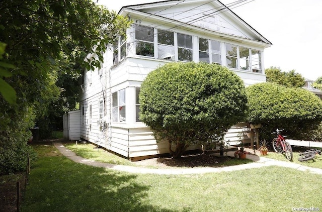 view of side of home with a yard