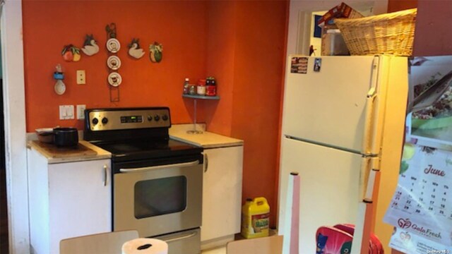 kitchen with white fridge and stainless steel range with electric cooktop