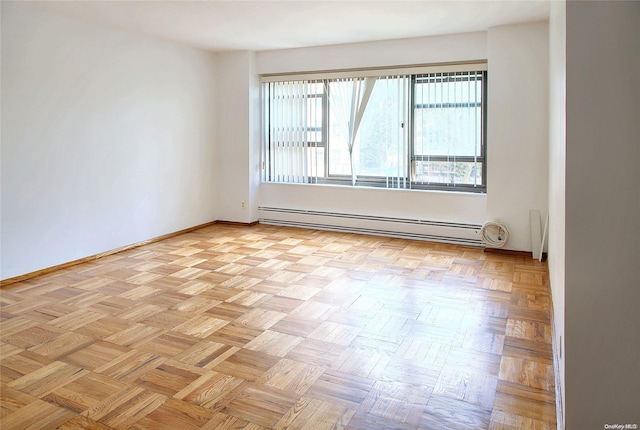 unfurnished room featuring baseboard heating and light parquet floors