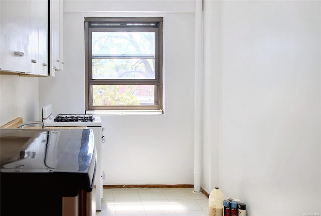 21-85 34th Ave Unit 3B, Astoria, NY 11106 - kitchen with baseboards, white range with gas cooktop, and white cabinetry