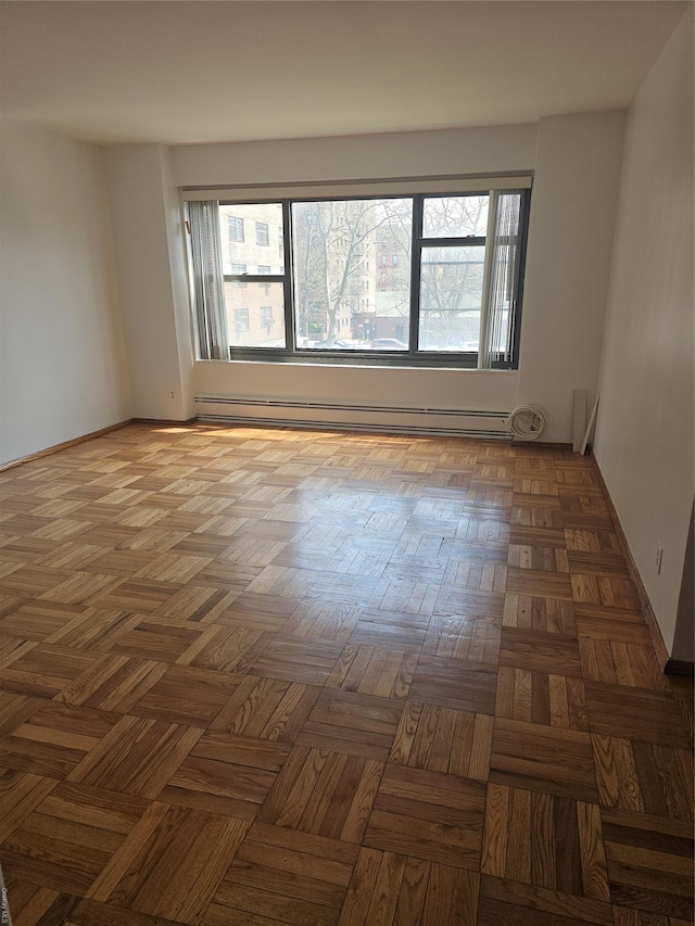 21-85 34th Ave Unit 3B, Astoria, NY 11106 - empty room with a baseboard heating unit, healthy amount of natural light, and baseboards